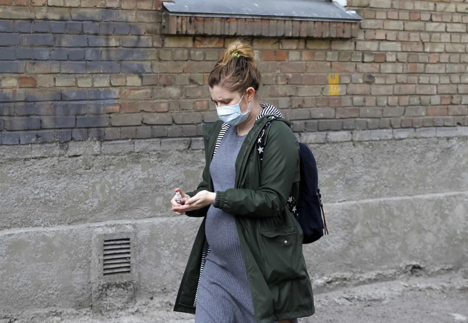 KIEV, UKRAINE - 2020/04/13: A pregnant woman wearing a face mask as a preventive measure against the spread of coronavirus disinfects her hands on the street. As on 13 April 2020 were 3102 laboratory confirmed of the COVID-19 coronavirus cases in Ukraine, 93 of which were lethal, 97 patients recovered. During the day, 325 new cases were recorded. (Photo by Pavlo Gonchar/SOPA Images/LightRocket via Getty Images)