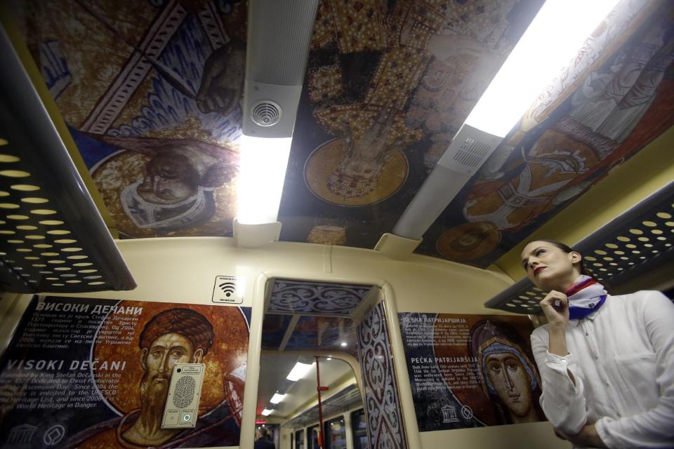A train hostess stands in a train carriage decorated with the iconic figures as it departs from the Belgrade to Mitrovica, Kosovo at Belgrade's railway station, Serbia, Saturday, Jan. 14, 2017. Serbia has launched a railway link to Serb-dominated northern Kosovo despite protests from authorities in Pristina who described the move as a provocation and an aggressive violation of Kosovo's sovereignty. .(AP Photo/Darko Vojinovic)