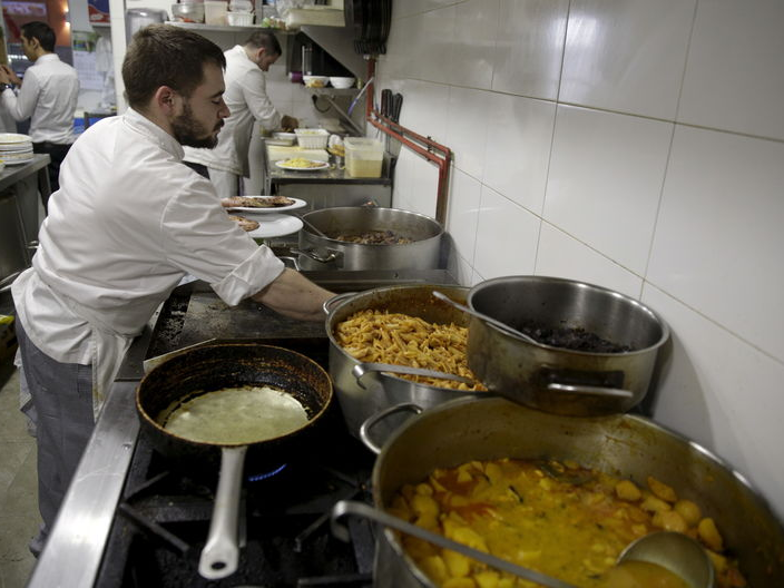 Cooks work inside a kitchen of a restaurant belonging to the owner of the JC Rooms brand in Madrid, Spain, December 15, 2015. REUTERS/Andrea Comas