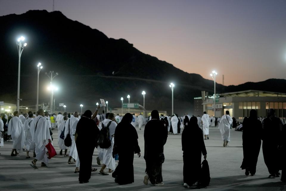 Muslim pilgrims walk to cast stones at a pillar in the symbolic stoning of the devil, during the last rite of the annual hajj, and the first day of Eid al-Adha, in Mina near the city of Mecca, Saudi Arabia, Saturday, July 9, 2022. (AP Photo/Amr Nabil)