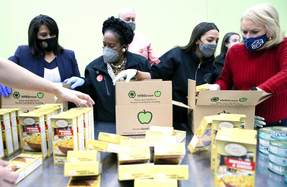 Texas congresswoman Penny Morales Shaw, from left, joins U.S. Representatives Sheila Jackson Lee, Alexandria Ocasio-Cortez and Sylvia Garcia,  as they fill boxes at the Houston Food Bank on Saturday, Feb. 20, 2021.