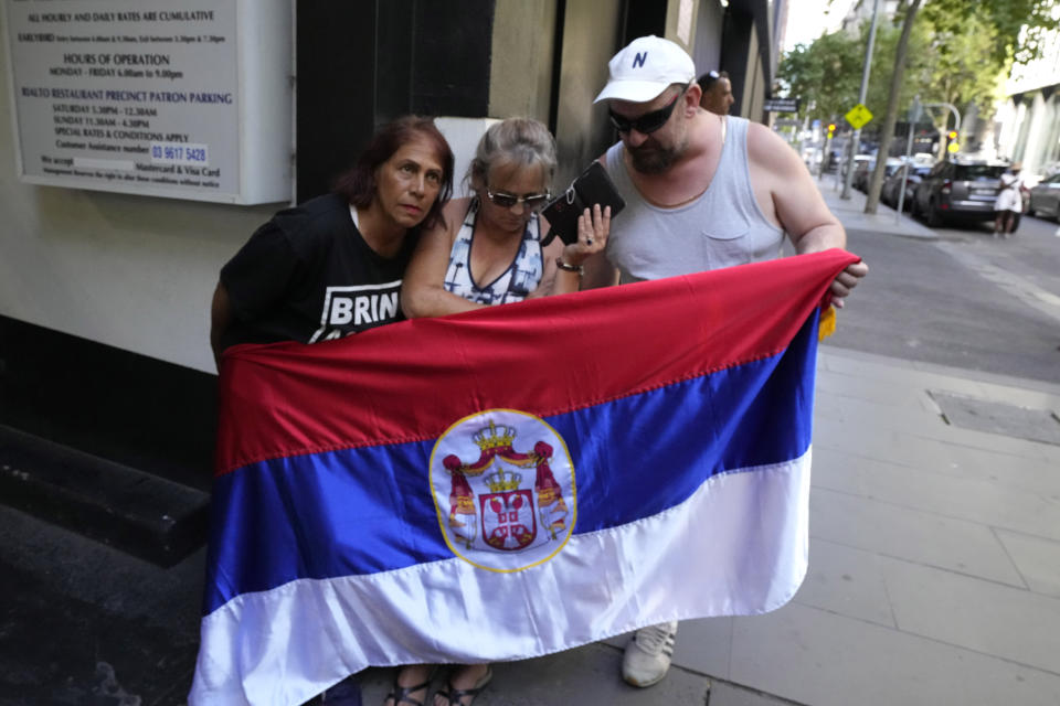 Supporters of Serbia's Novak Djokovic listen to his ruling outside the lawyer's office of Djokovic in Melbourne, Australia, Sunday, Jan. 16, 2022. Djokovic’s hopes of playing at the Australian Open were dashed Sunday after a court dismissed the top-ranked tennis star’s appeal against a deportation order. (AP Photo/Mark Baker)