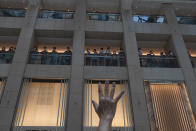 A protester gestures with five fingers, signifying the "Five demands - not one less" in a shopping mall during a protest against China's national security legislation for the city, in Hong Kong, Monday, June 1, 2020. The mouthpiece of China's ruling Communist Party says U.S. moves to end some trading privileges extended to Hong Kong grossly interfere in China's internal affairs and are doomed to fail. (AP Photo/Vincent Yu)