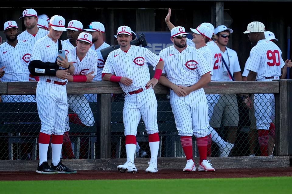 The Cincinnati Reds bench smiles and takes photos prior to the first inning of a game against the Chicago Cubs, Thursday, Aug. 11, 2022, at the MLB Field of Dreams stadium in Dyersville, Iowa. 