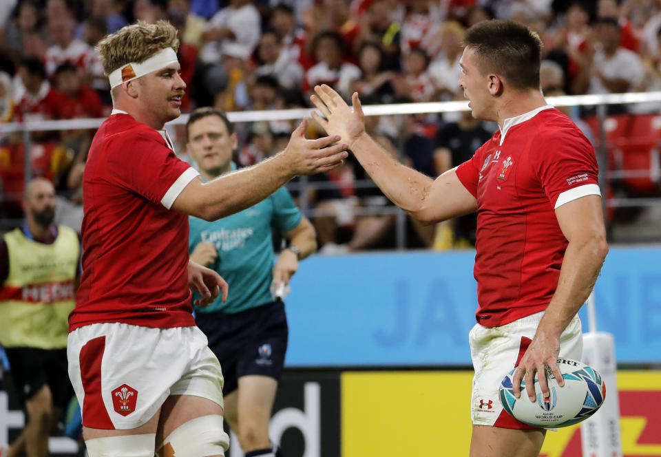 Wales Josh Adams, right, is congratulated by teammate Aaron Wainwright after scoring his side's third try during the Rugby World Cup Pool D game between Wales and Georgia at Toyota City Stadium, Toyota City, Japan, Monday, Sept. 23, 2019. (AP Photo/Christophe Ena)