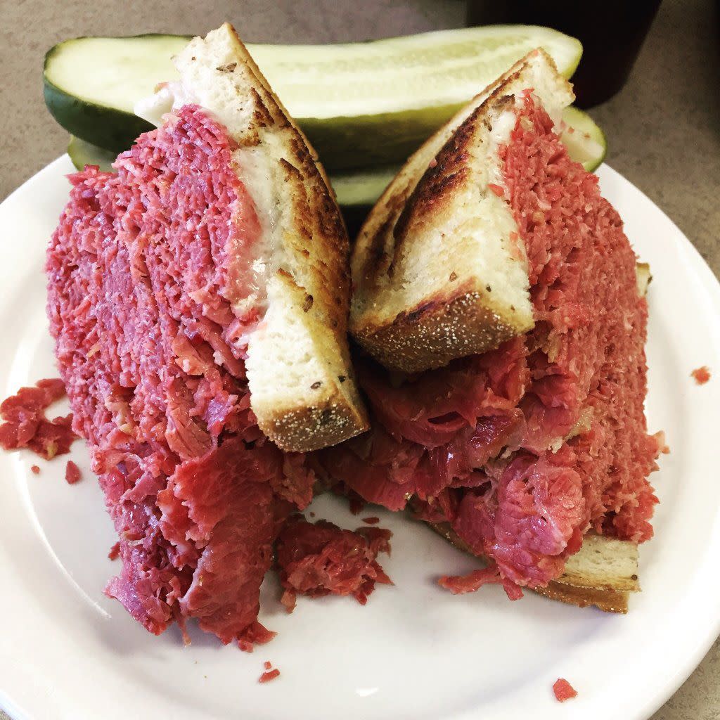 corned beef sandwich on stack of plates