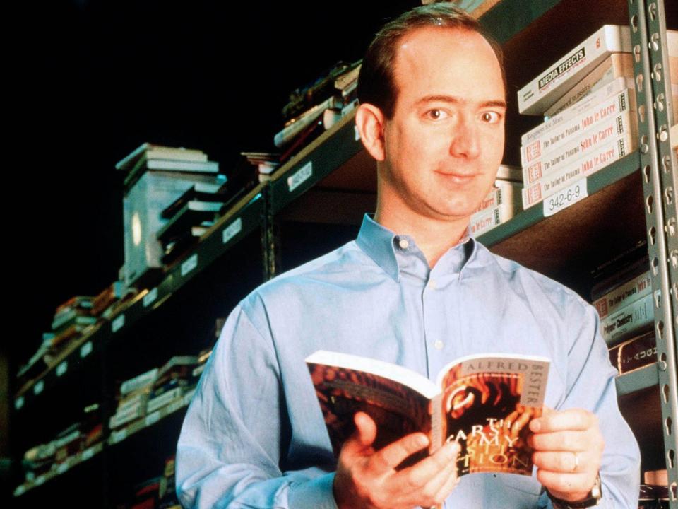 Jeff Bezos, founder & CEO of Amazon.com, poses with a book in an Amazon warehouse, Seattle, Washington, January 1st 1997.