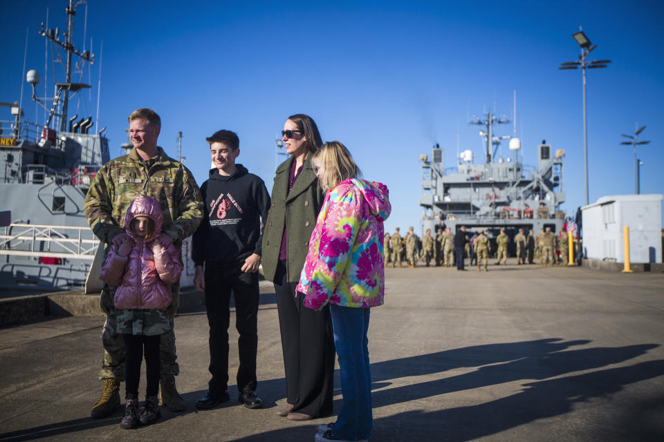 CW3 Jason West, left, skipper for LSV SP/4 James A. Loux, 7th Transportation Brigade (Expeditionary), stands with his family before deploying on Tuesday, March 12, 2024, at Joint Base Langley-Eustis in Hampton, Va. (AP Photo/John C. Clark)