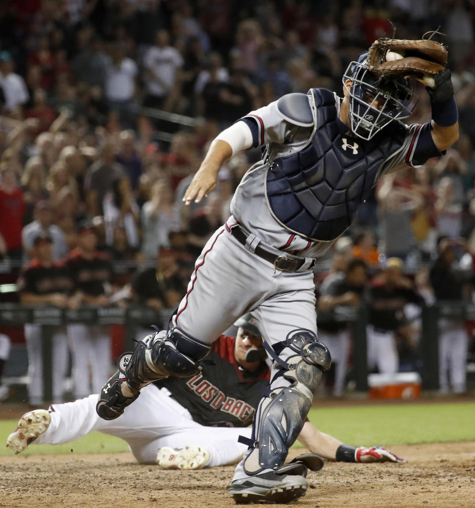 Atlanta Braves catcher Kurt Suzuki celebrates after tagging Arizona Diamondbacks' Nick Ahmed at the plate to end the baseball game Saturday, Sept. 8, 2018, in Phoenix. The Braves won 5-4 in 10 innings. (AP Photo/Matt York)