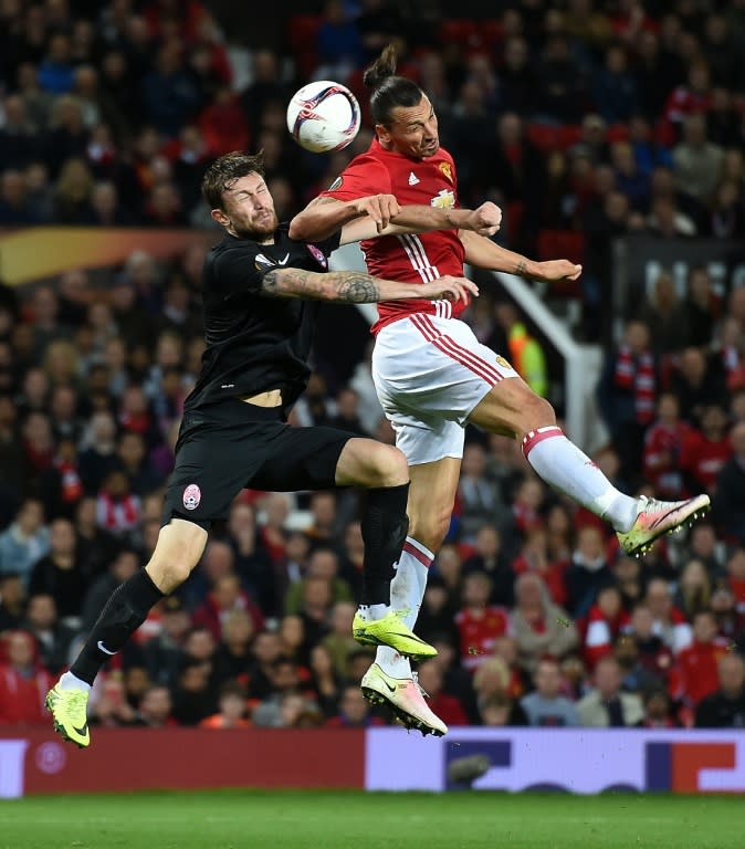 Manchester United's striker Zlatan Ibrahimovic (R) vies in the air with Zorya's defender Mikhail Sivakov as he heads the ball towards goal during the UEFA Europa League group A football match between Manchester United and Zorya Luhansk