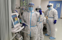 In this photo released by Chinese nurse Zhang Dan, she poses for a photo while working at the Tongji hospital in Wuhan in central China's Hubei province, Saturday, Feb. 22, 2020. Zhang was among the first to respond to the call for help in China's coronavirus epicenter. The 36-year-old nurse worked through grueling days, ministering to patients who needed assistance from breathing to merely eating. She struggled — but then, a little street dog helped her through. (Zhang Dan via AP)