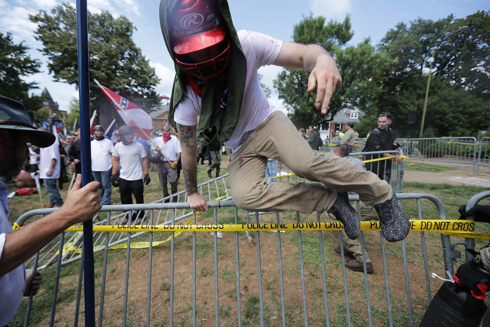 <p>White nationalists, neo-Nazis and members of the “alt-right” leap over barricades inside Lee Park during the “Unite the Right” rally Aug. 12, 2017 in Charlottesville, Va. (Photo: Chip Somodevilla/Getty Images) </p>