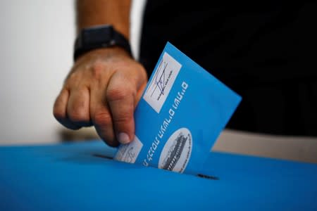 A man casts his vote in a ballot box during Israel's parliamentary election, at a polling station in Tel Aviv, Israel