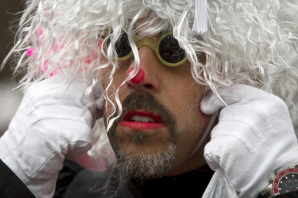 A clown adjusts his wig as he gets ready to participate in the Macy's Thanksgiving Day Parade in New York