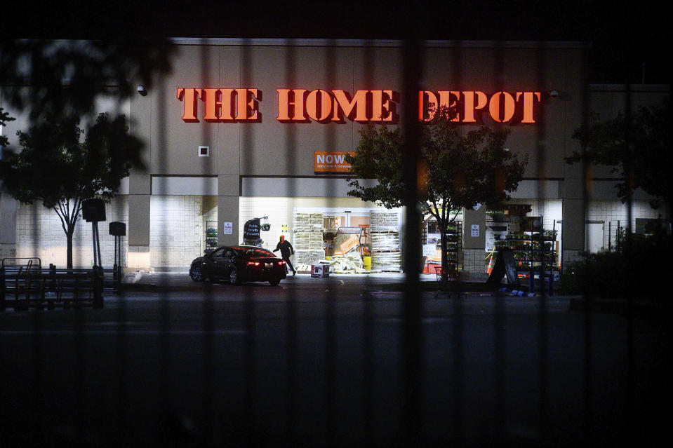 FILE - In this June 1, 2020, file photo, a man leaves a vandalized Home Depot store in Oakland, Calif. Police say many of the smash-and-grab thefts have been carried out by caravans of well-coordinated criminals that have coincided with or followed protests over the death of George Floyd, who was killed by a Minneapolis police officer who pressed his knee into Floyd's neck. (AP Photo/Noah Berger, File)