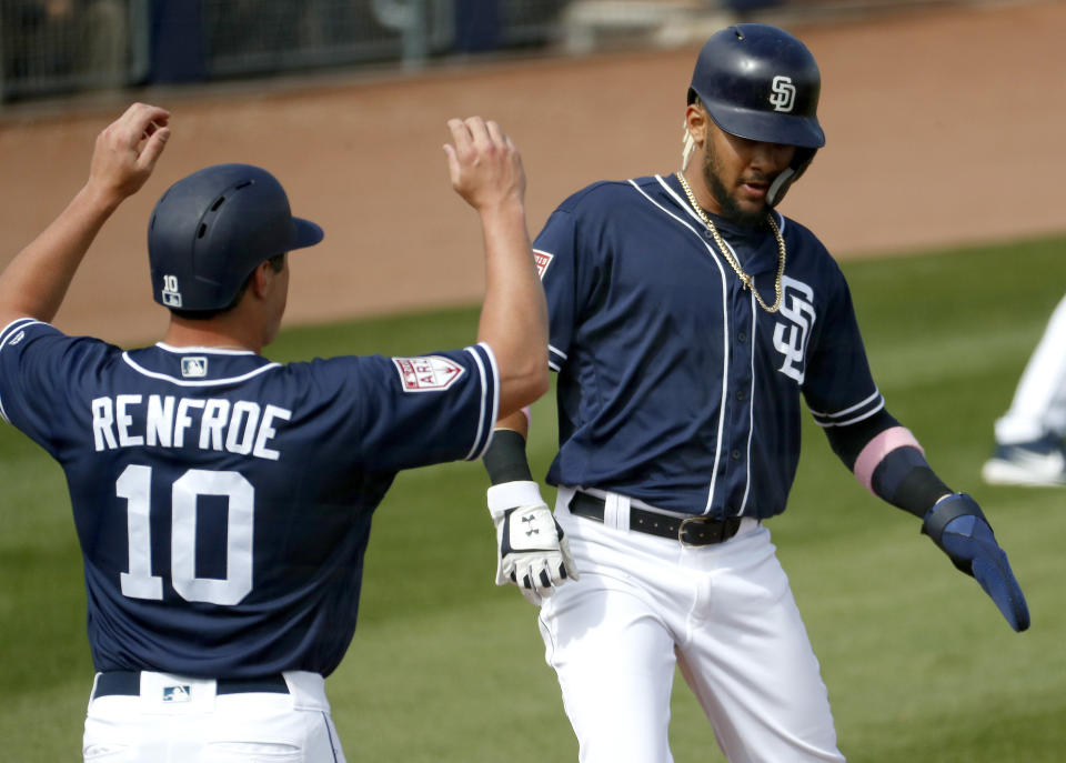 San Diego Padres' Fernando Tatis Jr. and Hunter Renfroe (10) score on a double by teammate Ian Kindler during the second inning of a spring training baseball game against the San Francisco Giants, Saturday, March 2, 2019, in Peoria, Ariz. (AP Photo/Matt York)