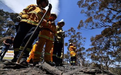 Firefighters monitor bush fire spot at the Woodford residential area in Blue Mountains - Credit: SAEED KHAN/AFP