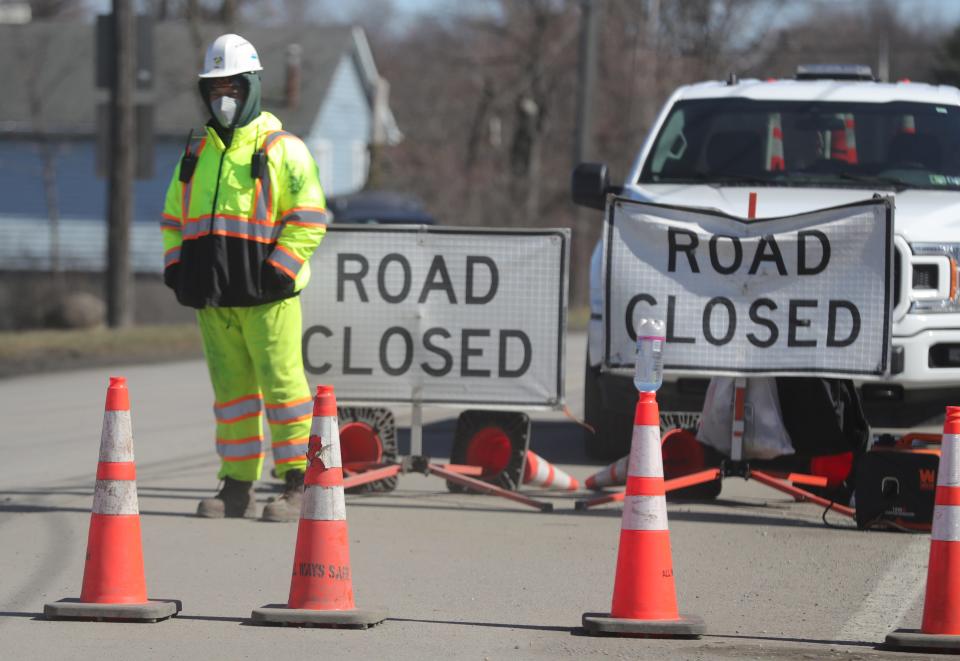 A worker keeps watch near the East Taggert Street railroad crossing as cleanup from a Norfolk Southern derailment continues on Tuesday, March 7, 2023 in East Palestine.