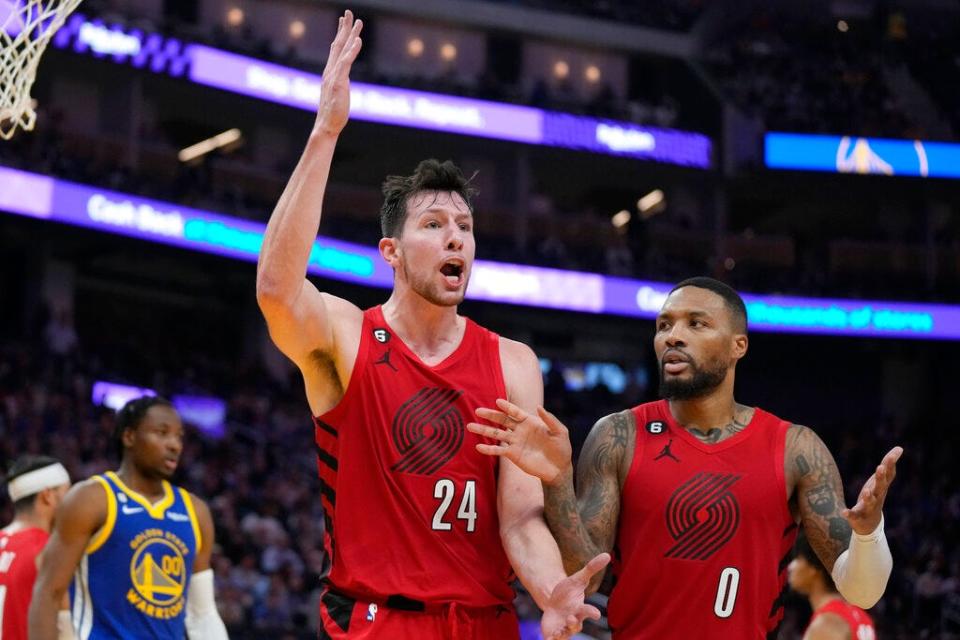 Portland Trail Blazers forward Drew Eubanks (24) and guard Damian Lillard (0) react during an NBA basketball game against the Golden State Warriors in San Francisco, Friday, Dec. 30, 2022. (AP Photo/Jeff Chiu)