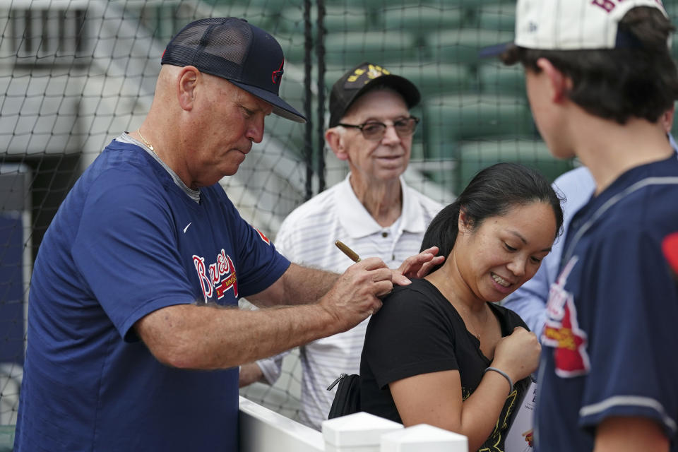 Atlanta Braves manager Brian Snitker signs an autograph before a baseball game against the Philadelphia Phillies Tuesday, Sept. 19, 2023. (AP Photo/John Bazemore)