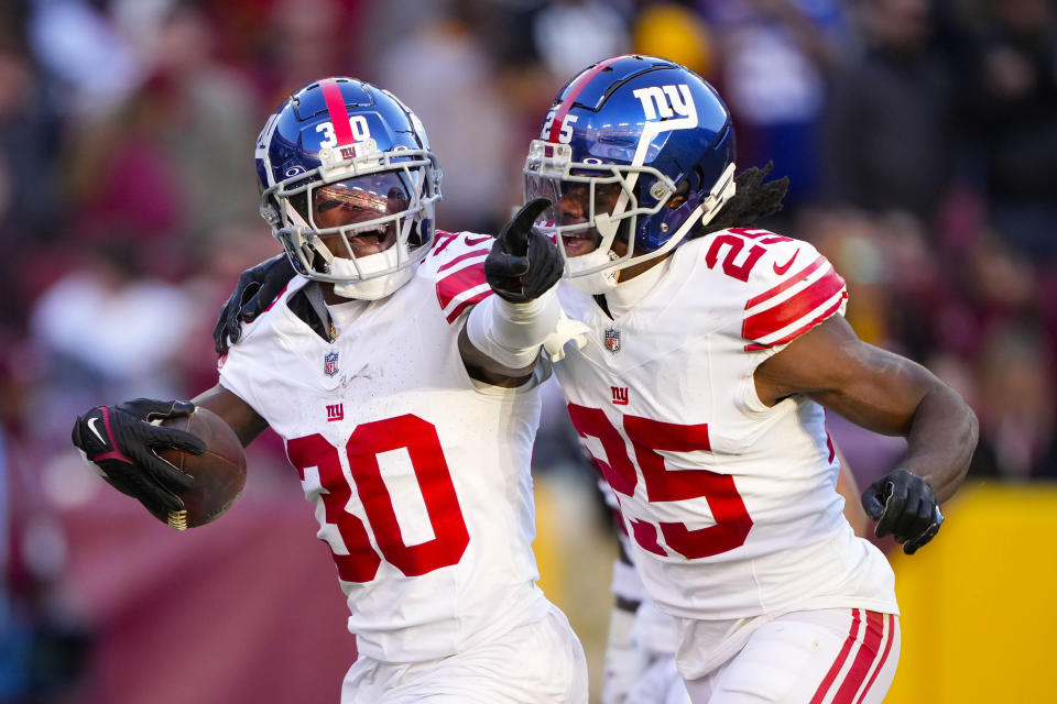 New York Giants cornerback Darnay Holmes (30) celebrates his interception with teammate cornerback Deonte Banks (25) against the Washington Commanders during the second half of an NFL football game, Sunday, Nov. 19, 2023, in Landover, Md. (AP Photo/Andrew Harnik)