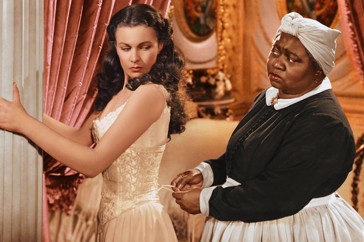 Vivien Leigh (1913-1967), British actress, has her corset tightened by Hattie McDaniel (1892–1952), US actress, in a publicity still issued for the film, 'Gone with the Wind', 1939