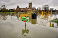 Children's playground equipment pokes out from floodwater surrounding Tewkesbury Abbey, where flood watches are in place with more wet weather expected in the coming days.