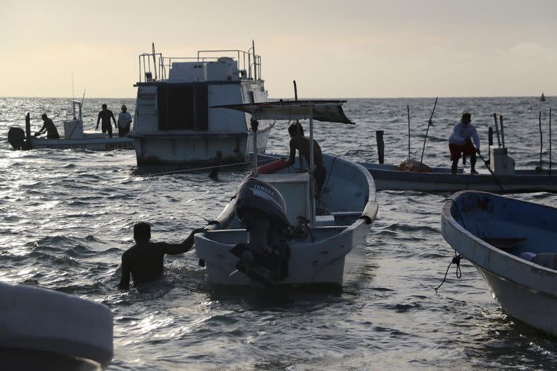 Fishermen prepare to take their boats off the water as Hurricane Zeta approaches Cancun