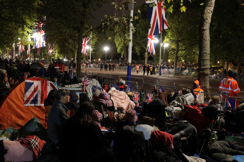 Gente se sienta y duerme en el Mall durante la noche en el día del funeral de estado y el entierro de la reina Isabel II en Londres, Reino Unido