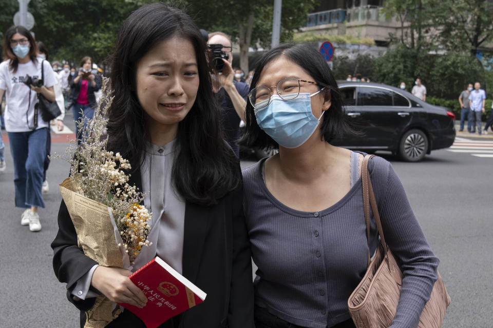 FILE - Zhou Xiaoxuan, left, a former intern at China's state broadcaster CCTV, reacts as she arrives to attend a court session at a courthouse in Beijing, Tuesday, Sept. 14, 2021. Zhou, who accused well-known state TV host Zhu Jun of groping her when she was an intern and was once praised for her courage in speaking up, faced a campaign of harassment and can no longer post on her public-facing accounts. (AP Photo/Mark Schiefelbein, File)