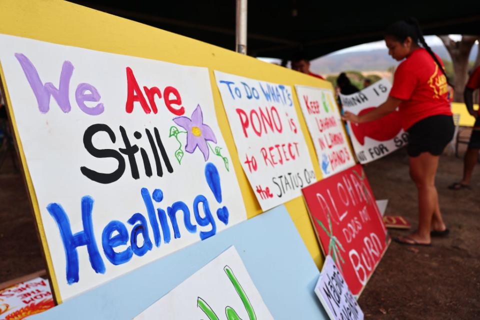 A community member hangs a sign at a 'Lahaina Strong' gathering on October 6, 2023 in Lahaina, Hawaii. Community members painted signs expressing their opposition to the October 8th start of tourists returning to west Maui following the devastating wildfire.