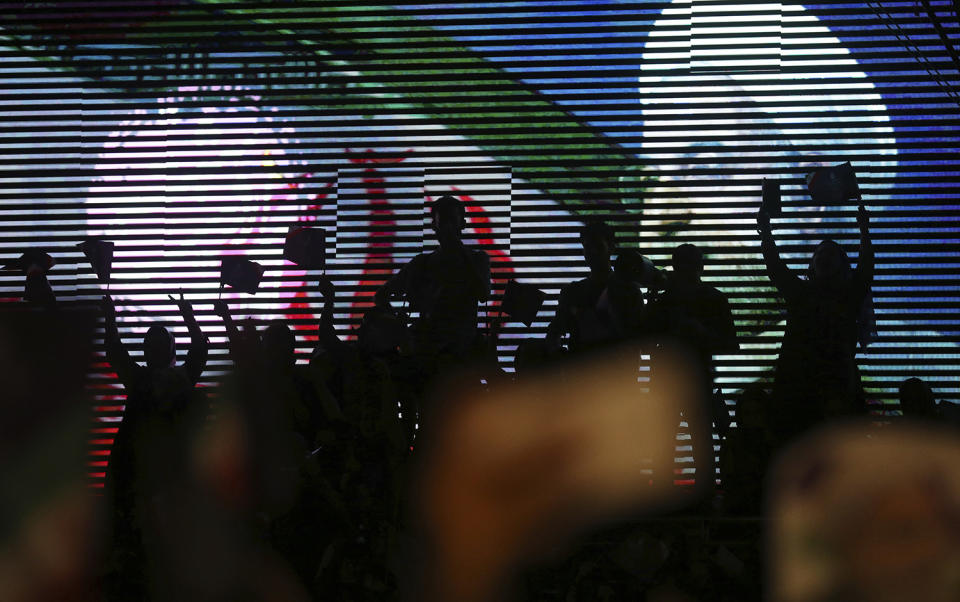 <p>Supporters of Iranian President Hassan Rouhani for May 19 presidential election wave flags and posters while silhouetted in front of a screen showing picture of Rouhani in a campaign rally in Tehran, Iran, May 9, 2017. (Photo: Vahid Salemi/AP) </p>