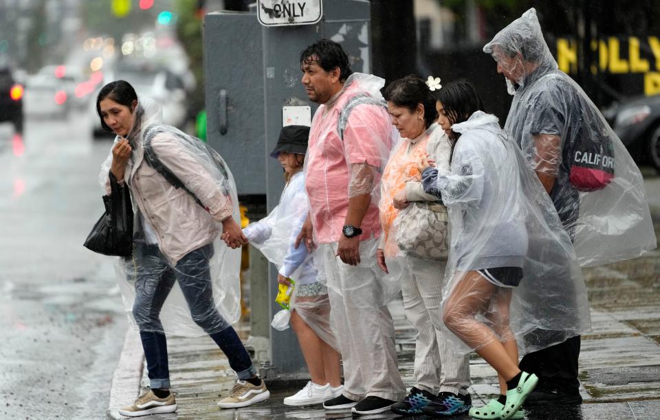 Pedestrians fight strong winds and rain on Hollywood Boulevard during Tropical Storm Hilary, Sunday, Aug. 20, 2023, in Los Angeles. (AP Photo/Chris Pizzello)