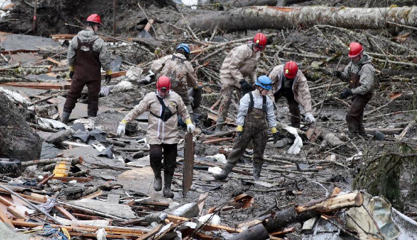 Workers comb through debris at the site of a deadly mudslide, Friday, March 28, 2014, in Oso, Wash. Besides the 26 bodies already found, dozens more people could be buried in the debris pile left from the mudslide nearly one week ago. (AP Photo/Lindsey Wasson, Pool)