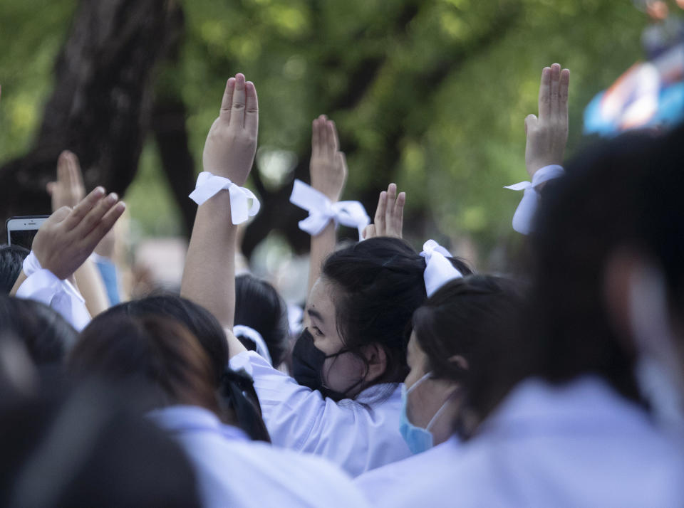 Pro-democracy students raise a three-fingers, symbol of resistance salute during a protest rally in front of Education Ministry in Bangkok, Thailand, Wednesday, Aug. 19, 2020. Student protesters have stepped up pressure on the government with three core demands: holding new elections, amending the constitution and ending the intimidation of critics of the government. (AP Photo/Sakchai Lalit)