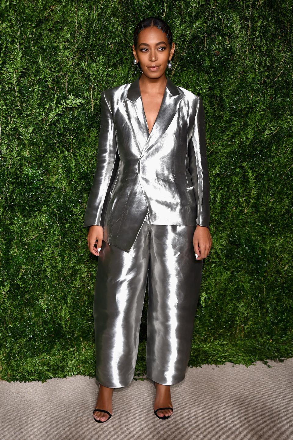 Solange in a two piece silver metallic suit