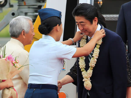 Japanese Prime Minister Shinzo Abe receives a garland upon his arrival for a state visit in metro Manila, Philippines January 12, 2017. REUTERS/Romeo Ranoco