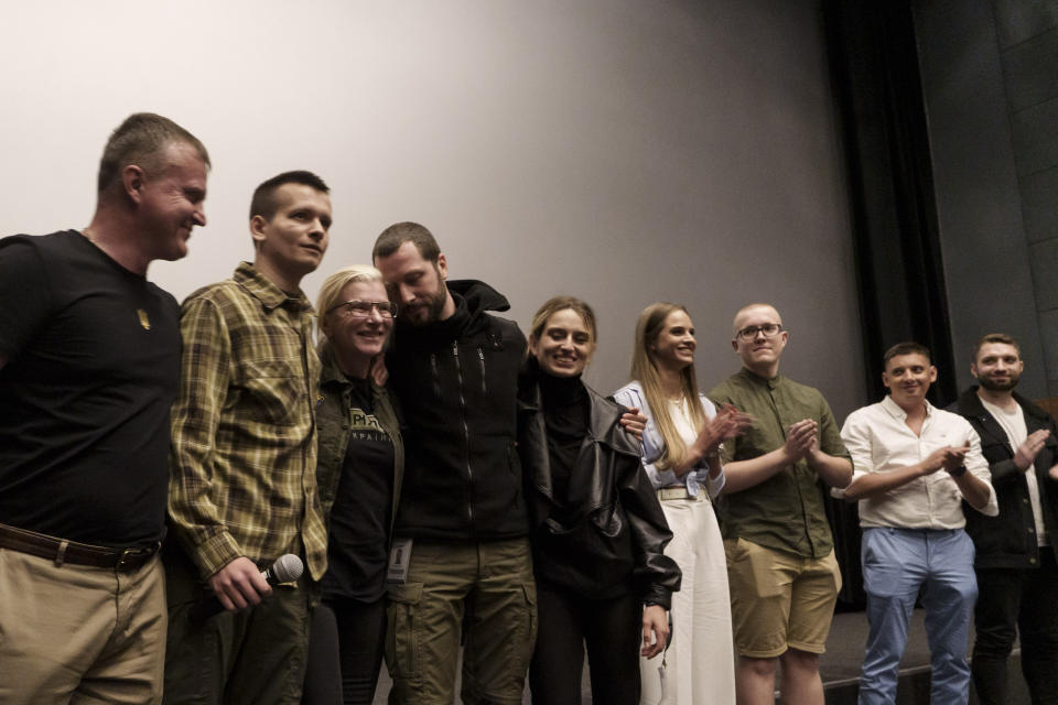 From left to right; Mariupol police officer Volodymyr Nikulin, military medic Serhii Chornobrivets, medic Yuliia 'Taira' Paievska, The Associated Press journalist and film director Mstyslav Chernov, The Associated Press journalist Vasilisa Stepaneko, medic Lyidmyla Vaskovska and other medics from Mariupol, gather at the end of the Ukrainian premiere of the documentary film "20 Days in Mariupol" in Kyiv, Ukraine, Saturday, June 3, 2023. (AP Photo/Roman Hrytsyna)