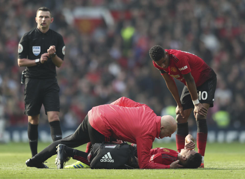 Manchester United's Jesse Lingard lays on the pitch after getting injured during the English Premier League soccer match between Manchester United and Liverpool at Old Trafford stadium in Manchester, England, Sunday, Feb. 24, 2019. (AP Photo/Jon Super)