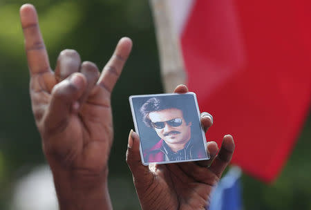 A picture of actor Rajinikanth is shown by a supporter as they celebrate the launch of his political party in Chennai, India, December 31, 2017. REUTERS/P. Ravikumar