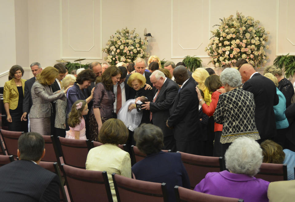 In this 2012 photo provided by a former member of the church, Word of Faith Fellowship leader Jane Whaley, center, holds a baby with others during a church ceremony in Spindale, N.C. From all over the world, they flocked to a tiny North Carolina town in the foothills of the Blue Ridge Mountains, lured by promises of inner peace and eternal life. What many found instead: years of terror _ waged in the name of the Lord. (AP Photo)