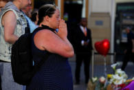 People look upon the flowers, messages and tokens left in tribute to the victims of the attact on Manchester Arena, in central Manchester, Britain May 26, 2017. REUTERS/Stefan Wermuth