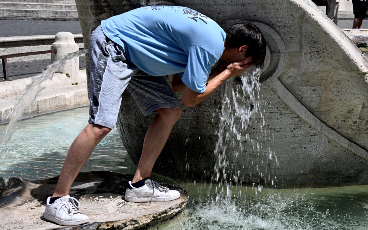 A boy cools down at the Barcaccia fountain in front of the Scalinata di Trinita dei Monti (Spanish Steps) in Rome on July 17, 2023, during a heatwave in Italy. Unforgiving heat scorched parts of the Northern Hemisphere on July 17, triggering health warnings and fanning wildfires in the latest stark reminder of the effects of global warming.