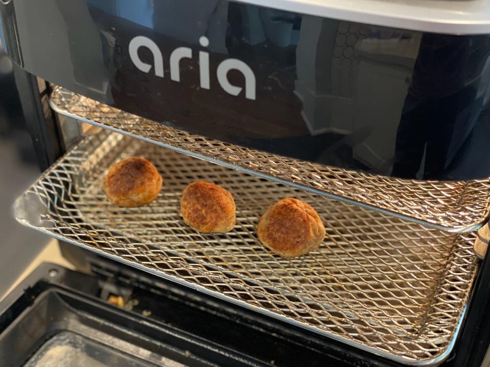 three meatballs inside an air fryer