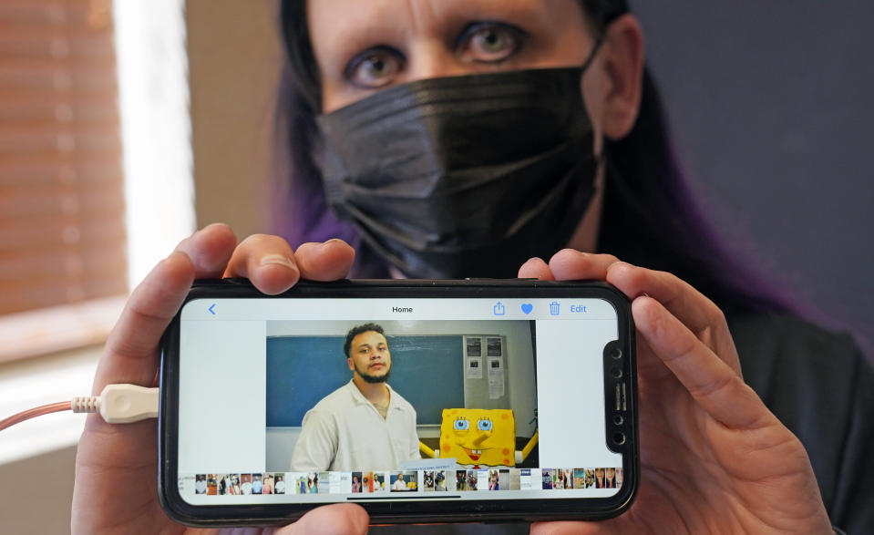 Carrie Shipp shows a photo of her incarcerated 21-year-old son Matthew Shipp that she keep on her cell phone Friday, April 2, 2021, in Irving, Texas. Fewer than 20 percent of state and federal prisoners have received a COVID-19 vaccine, according to data collected by The Marshall Project and The Associated Press. Carrie Shipp said her son decided not to get vaccinated out of fear and distrust of prison medical staff. (AP Photo/LM Otero)