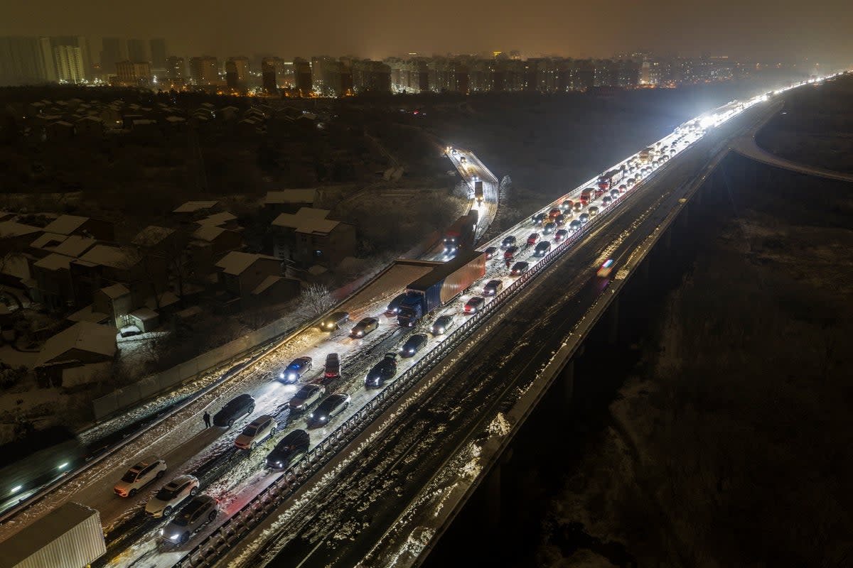 Vehicles stranded on a snow-covered highway on the outskirts of Wuhan in central China’s Hubei province (AP)