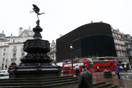 A man looks at the advertisement boards at Piccadilly Circus which have been switched off prior to being replaced with more modern screens, in central London, Britain January 16, 2017. REUTERS/Stefan Wermuth,