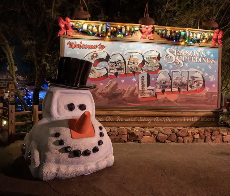 a sign that says "Welcome to Cars Land — Season's Greetings"