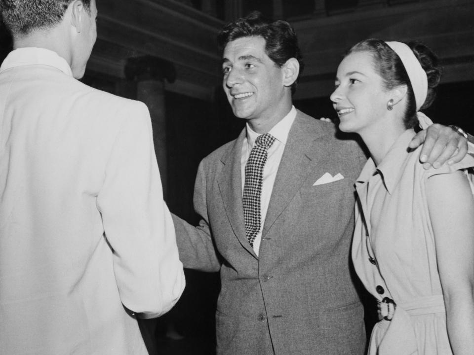 Leonard Bernstein stands with his arm around Felicia Montealegre in a photo taken at the Tanglewood music institute in 1946.