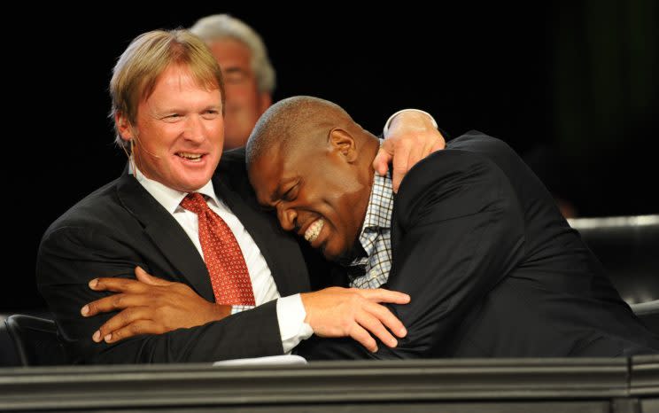 Jon Gruden, getting a hug from Charles Haley, said he wants to coach in the NFL again. (AP)